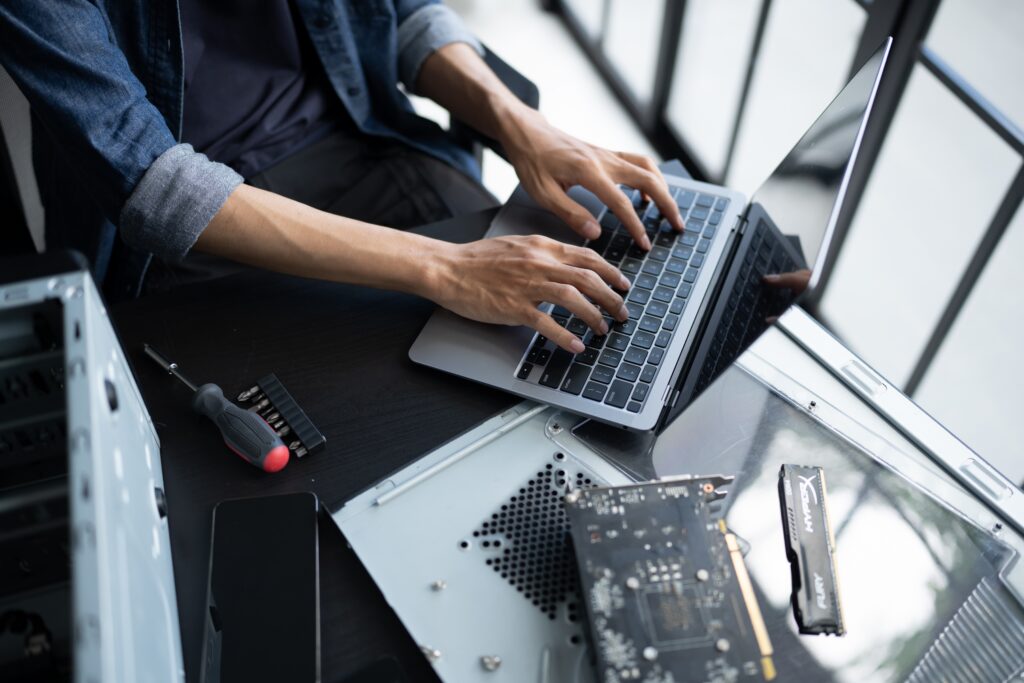 Closeup of an engineer's hands as they repair a laptop