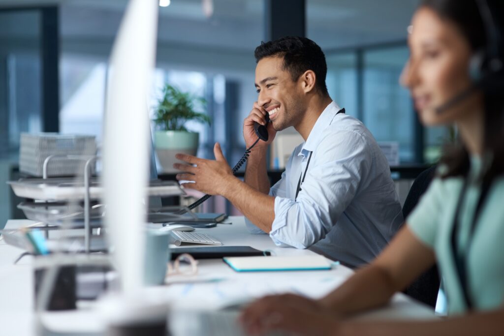Two happy customer support coordinators helping customers on the phone